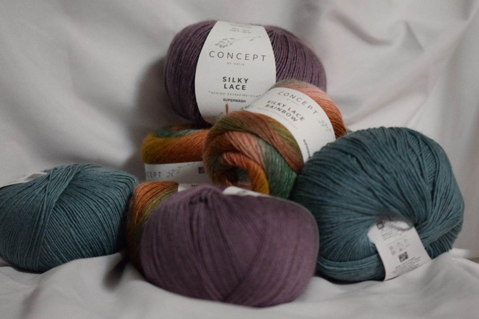 Nystan av Katia Silky Lace och Silky Lace Rainbow i lila, grönt och flerfärgat garn.