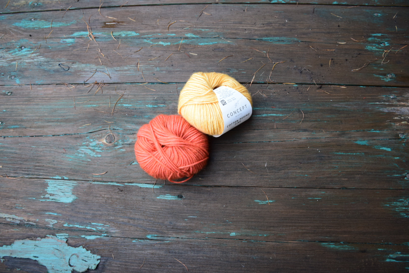 Nystan av Katia Cotton Merino Fine i varma nyanser på rustik träbakgrund